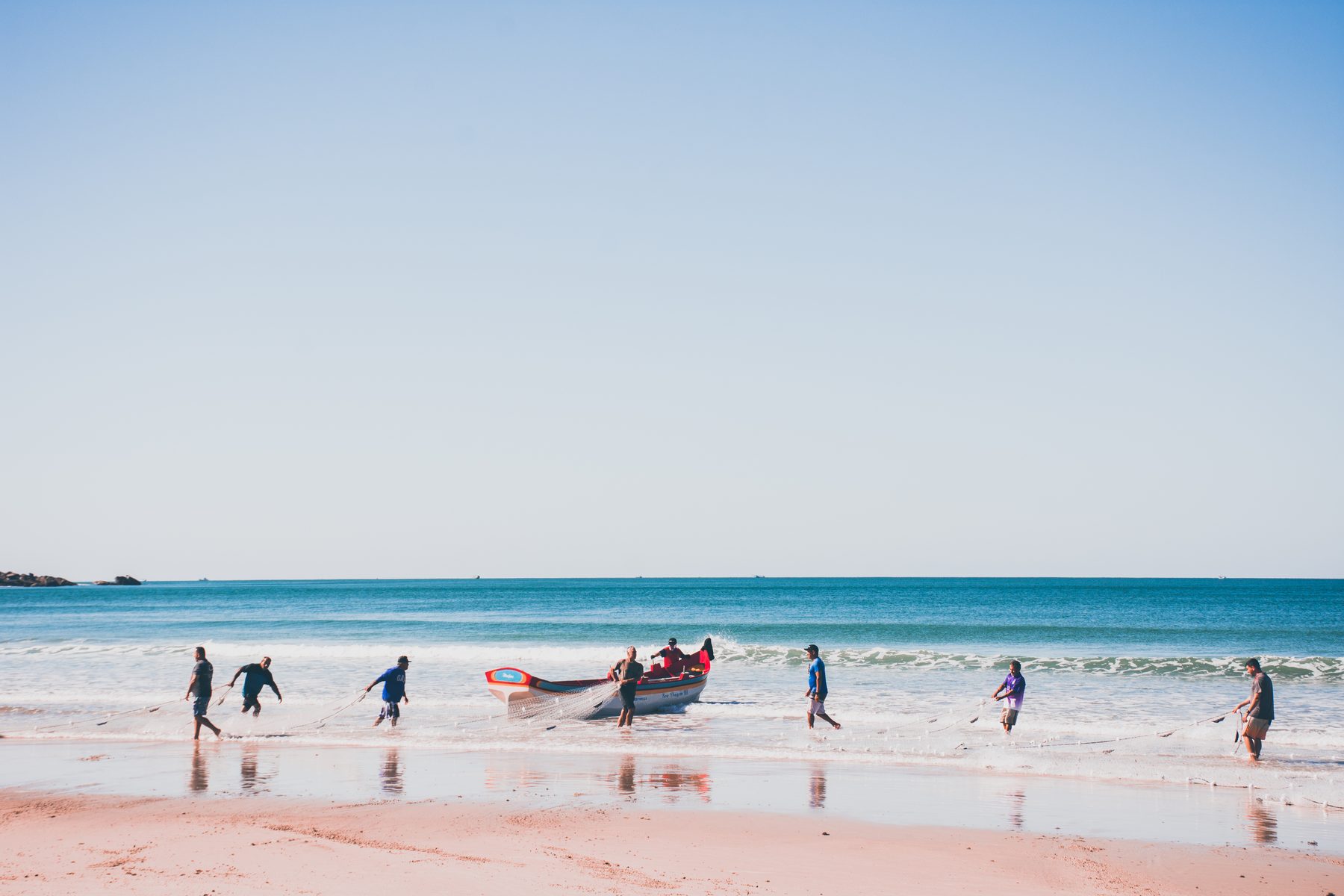 Men on the beach hauling in the net